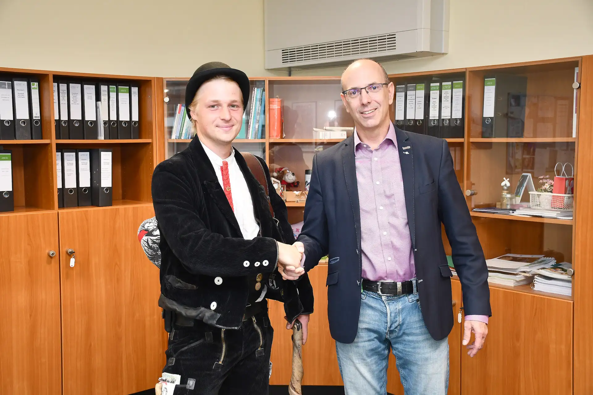 Zwei Personen stehen nebeneinander, eine Person spricht mit der anderen.