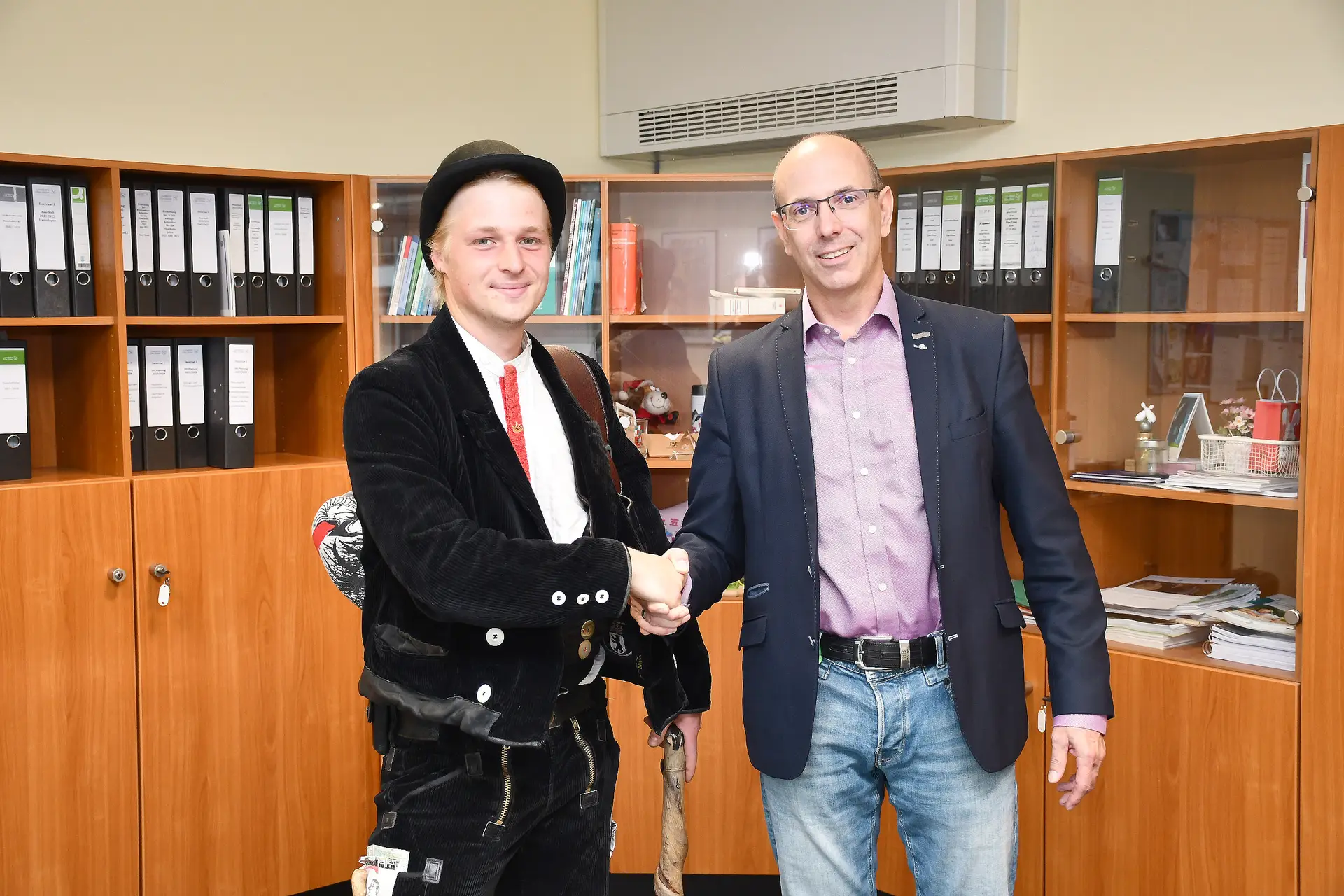 Zwei Personen stehen nebeneinander, eine Person spricht mit der anderen.