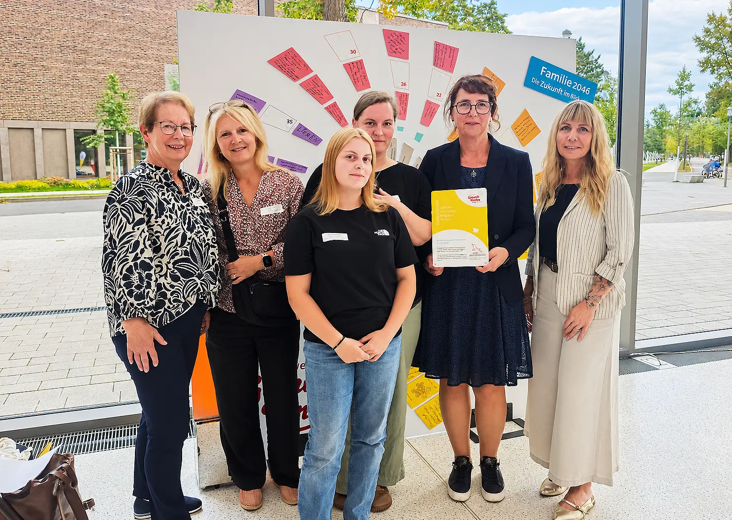 Mehrere Personen posieren gemeinsam für ein Foto im Rahmen eines Jubiläums.