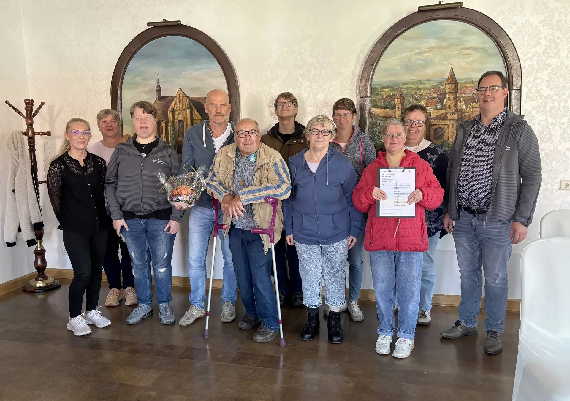 Lernende des Grundbildungszentrums Elbe-Elster und Teilnehmende der ElsterWerke sprechen im Standesamt des Herzberger Rathauses mit Bürgermeister Karsten Eule-Prütz.